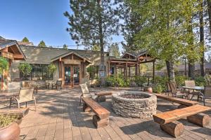 a patio with benches and a fire pit at Chic Bend Condo with Fireplace and Forest Views! in Bend