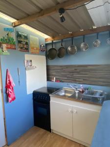 une cuisine avec un évier et un comptoir avec des casseroles et des poêles dans l'établissement Camping Atypique Manche SURVILLE, à Surville