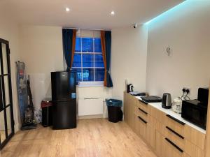 a kitchen with a refrigerator and a window at Not very quiet but best Location in London