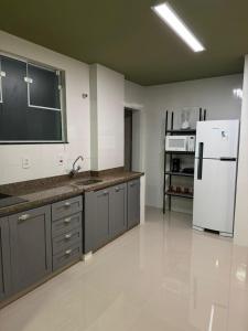 フランカにあるFantastico apto no Centro!のシンクと冷蔵庫付きのキッチン