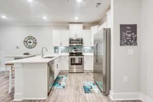 a kitchen with white cabinets and stainless steel appliances at Gorgeous Calabash Condo with Balcony and Pool Access! in Calabash