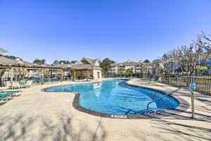 a swimming pool at a resort with chairs at Gorgeous Calabash Condo with Balcony and Pool Access! in Calabash