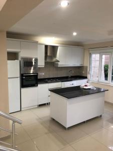 a kitchen with white cabinets and a black counter top at Pine Golf Village Belek in Belek