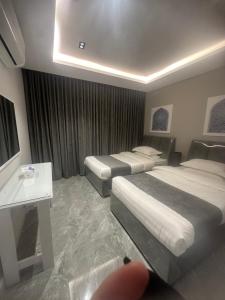 um quarto de hotel com duas camas e uma janela em Jamal Royal Apartments em Medina