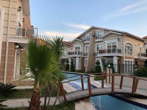 a building with a pool in front of a house at Pine Golf Village Belek in Belek