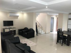 a living room with a couch and a dining room at Pine Golf Village Belek in Belek