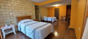 a room with two beds and a brick wall at Casa Cejota in Huautla de Jiménez +12 photos