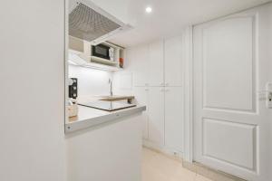 cocina con paredes blancas y puerta en Le Clos - Souplex 4p - Jardin & Piscine commune, en Chennevières-sur-Marne