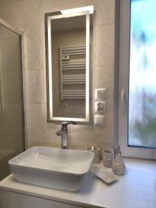 lavabo blanco en el baño con espejo en Villetta Rewal, en Rewal