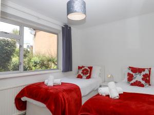 ein Wohnzimmer mit 2 Betten und einem Fenster in der Unterkunft Sunny Bank in Torquay