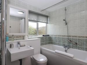 ein Badezimmer mit einem Waschbecken, einer Badewanne und einem WC in der Unterkunft Sunny Bank in Torquay