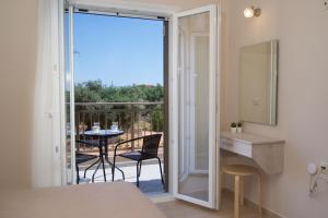 a bedroom with a door open to a patio with a table at Jasmine Maisonette in Razáta