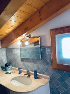 een badkamer met een wastafel en een houten plafond bij Sweet Dream House in Carloforte