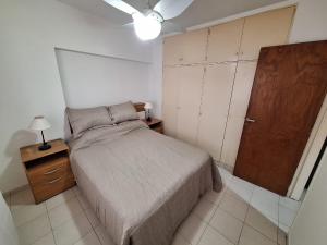 Schlafzimmer mit einem Bett und einer Holztür in der Unterkunft Bahía x día 1 in Bahía Blanca