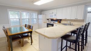 a kitchen with white cabinets and a table and chairs at Family Time by Tybee Vacation Rentals in Tybee Island