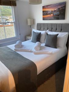 1 cama grande con 2 toallas encima en Fulmar Cottage, en Mevagissey