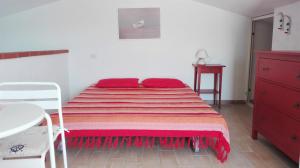 a bedroom with a bed and a red dresser at Holiday House La Rosa dei Venti in Palau