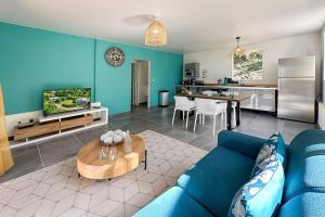 uma sala de estar com um sofá azul e uma mesa em Ti Sunset 2 Martinique Le Carbet em Le Carbet
