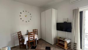 ein Esszimmer mit einem Tisch und einer Uhr an der Wand in der Unterkunft Villa Baldi -Apartmani Danny in Tar