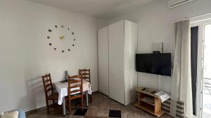 a dining room with a table and a clock on the wall at Villa Baldi -Apartmani Danny in Tar
