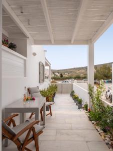 eine Terrasse mit Tisch und Stühlen auf einem Dach in der Unterkunft Studio Busho in Naoussa