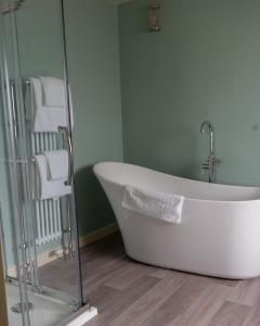 a bath tub in a bathroom with green walls at The Mallard Hotel in Gullane