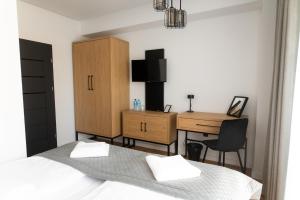 a bedroom with a desk and a bed and a deskicterictericterictericter at Apartamenty Loftove in Wadowice