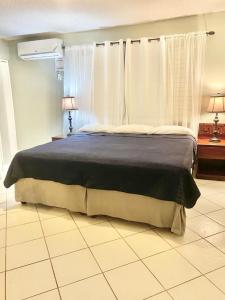 a bedroom with a large bed with a blue blanket at Mystic Ridge Resort in Ocho Rios +48 photos