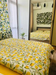 - une chambre avec un grand lit et une couette jaune dans l'établissement Old Batumi, à Batoumi