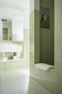 a bathroom with a shower with a white tile floor at Bay Plaza Hotel in Wellington
