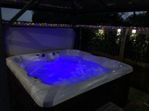 uma banheira de hidromassagem com luzes no quintal em Spacious Lodge With Hot Tub em Lincolnshire
