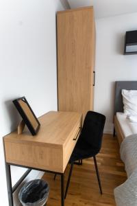 a desk in a bedroom with a bed and a chair at Apartamenty Loftove in Wadowice