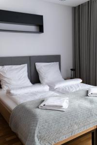 a large bed with white sheets and pillows at Apartamenty Loftove in Wadowice