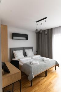 ein Schlafzimmer mit einem Bett mit weißen Kissen in der Unterkunft Apartamenty Loftove in Wadowice