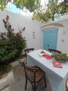 biały stół z krzesłami i niebieskie drzwi w obiekcie Dream House Little Villa - Amorgos w mieście Amorgós