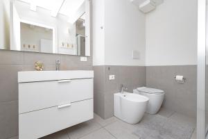 Baño blanco con lavabo y aseo en Suite 38, en Bérgamo