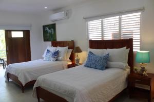 1 dormitorio con 2 camas y almohadas azules y blancas en VillasMana Complex PlayaBonita LasTerrenas Samana NearBeach WiFi, en Las Terrenas