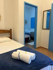 a bedroom with two towels on a bed and a mirror at Pousada Crocodilo Caraíva in Caraíva