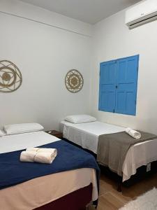 2 camas en una habitación con armarios azules en Pousada Crocodilo Caraíva, en Caraíva