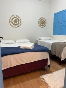 two beds in a room with blue cabinets at Pousada Crocodilo Caraíva in Caraíva