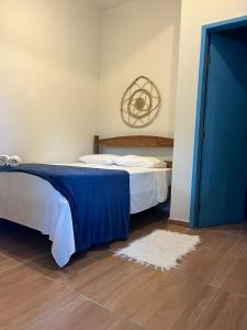 a bedroom with a bed and a blue door at Pousada Crocodilo Caraíva in Caraíva