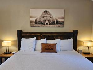 um quarto com uma cama com uma fotografia de urso na parede em Riverfront Motel & Cabins em Thompson Falls