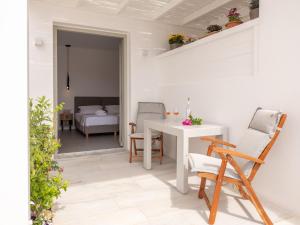 ein weißer Raum mit Tisch und Stühlen und ein Schlafzimmer in der Unterkunft Studio Busho in Naoussa