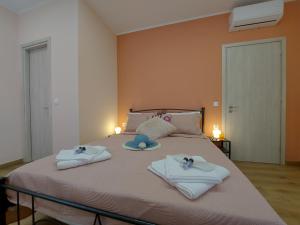 a bedroom with a bed with towels and hats on it at La casetta di Emilia in Corfu Town