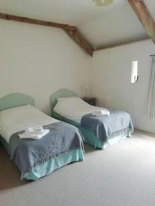 a room with two beds in a room at The Barn at Kingston, Beautiful converted barn in tranquil countryside in Pembroke