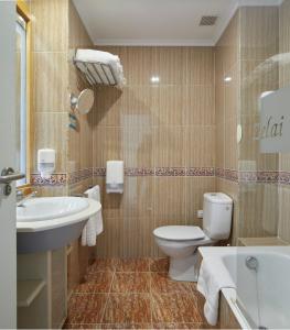 y baño con aseo, lavabo y bañera. en Hotel & Talasoterapia Zelai - HSS00653, en Zumaia