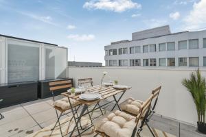 een patio met een tafel en stoelen op een balkon bij Appartement Chic au Coeur de Massy in Massy