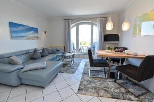 ein Wohnzimmer mit einer Couch und einem Tisch in der Unterkunft "Appartementhaus Deichgraf" Appartement D445 in Döse