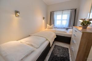 zwei Betten in einem kleinen Zimmer mit Fenster in der Unterkunft "Appartementhaus Deichgraf" Appartement D445 in Döse
