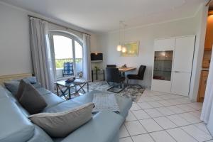 ein Wohnzimmer mit einer blauen Couch und einem Tisch in der Unterkunft "Appartementhaus Deichgraf" Appartement D445 in Döse